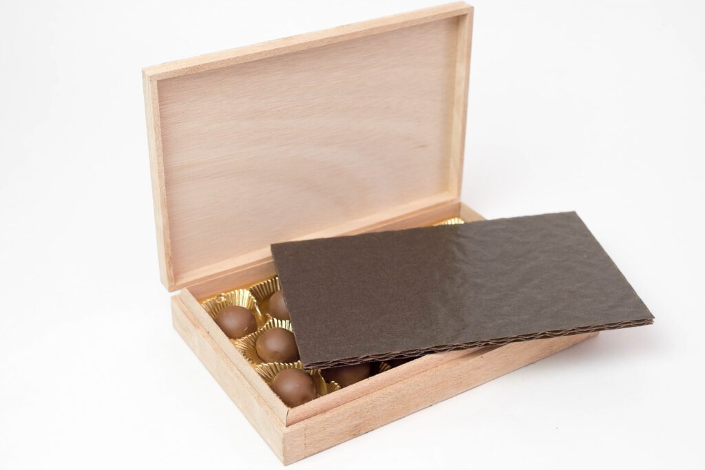 Schokolade in einer Holzbox und darauf liegt ein Papierkissen.